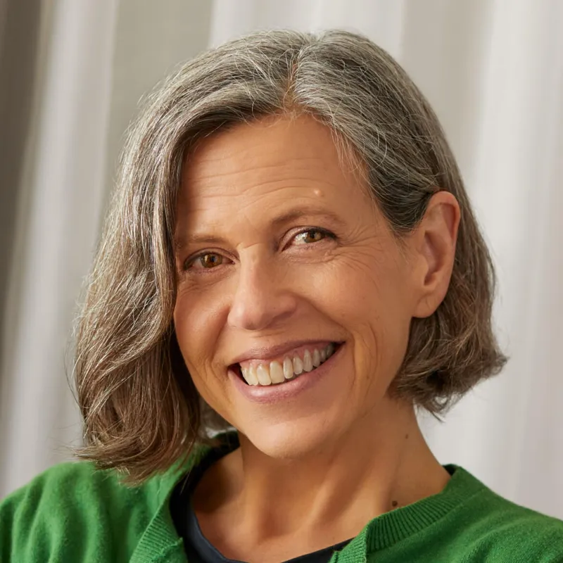 Michèle McBeigh, smiling, with short grey-brown hair and a green cardigan
